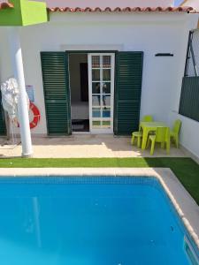a swimming pool in front of a house at Meco Beach and Private Pool Villa in Sesimbra