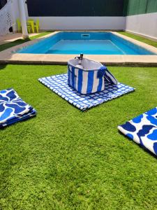a pool with a table and towels on the grass at Meco Beach and Private Pool Villa in Sesimbra