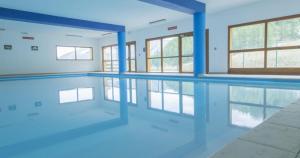 an empty swimming pool with blue walls and windows at Studio 4 pers in Les Orres