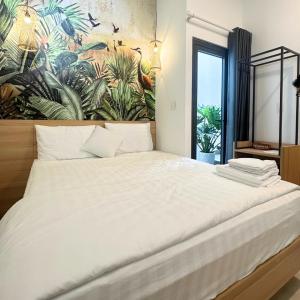 ein Schlafzimmer mit einem großen weißen Bett und einem Wandbild in der Unterkunft Couple Hotel - Khách Sạn Tình Yêu Hóc Môn in Ho-Chi-Minh-Stadt + 23 Fotos