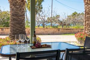 a table with wine glasses and a plate of grapes at Stefanie Studios in Egina