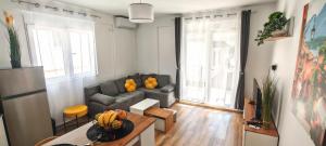 a living room with a couch and a table at Moderan apartman Klaudija in Igalo