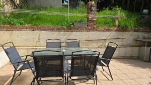 a table with four chairs and a glass top at Beautiful Family House near Paris in Villeneuve-Saint-Georges