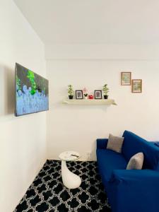 a living room with a blue couch and a table at Muzien B&B in Imola