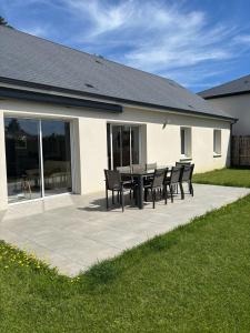 a patio with a table and chairs in front of a house at La Villa Coquette in Vouvray