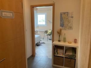 a hallway with a room with a bed and a table at Chambre indépendante avec vue sur mer et marais du littoral, Salle de bain et WC privatifs , kitchenette et terrasse partagées in Fontenay-sur-Mer