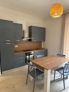 a kitchen with a wooden table and blue chairs at Locanda Francini in Badia A Passignano