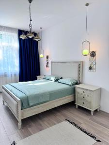una camera da letto con un letto con copriletto blu e un tavolo di Clock House a Bucarest