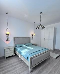 una camera da letto con un letto grande con lenzuola blu di Clock House a Bucarest