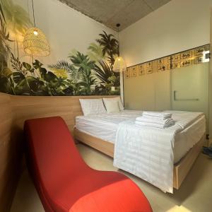 1 Schlafzimmer mit 2 Betten und einem roten Stuhl in der Unterkunft Couple Hotel - Khách Sạn Tình Yêu Hóc Môn in Ho-Chi-Minh-Stadt