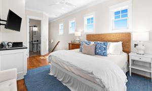 a bedroom with a large bed with a blue rug at Inlet Breeze in Inlet Beach +50 photos