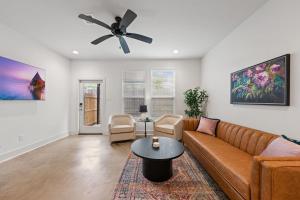 ein Wohnzimmer mit einer Couch und einem Deckenventilator in der Unterkunft NEW Thibodeaux House Cajun Luxury 65 TV Fast WiFi in Lafayette