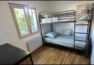a room with a bunk bed and a window at Cottage, L étrille, WIFI gratuit, proche de la mer, jardin, terrasse in Jullouville-les-Pins