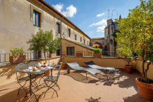 patio ze stołem i krzesłami na balkonie w obiekcie Vivaldi Luxury Rooms w Rzymie