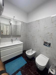 a white bathroom with a toilet and a sink at Sea view in Durrës