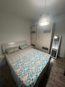 a bedroom with a bed with a blue and white comforter at Sea view in Durrës