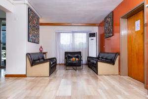 a living room with leather chairs and a fireplace at Résidences Les Hauts de l'Indenié in Abidjan