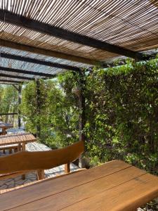 een houten tafel en bank onder een houten pergola bij Accommodation with an experience!!! Hostel Kantun in Punat