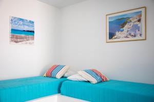 a blue couch with pillows in a room at Stefanie Studios in Egina