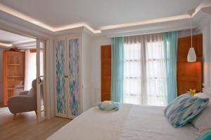 a bedroom with a large white bed with a window at Son Sant Jordi in Pollença