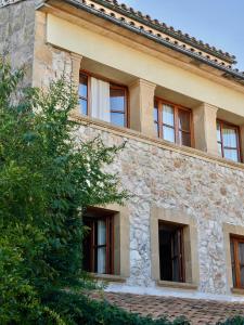 a stone building with windows and a tree at Son Sant Jordi in Pollença