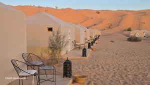 a row of chairs sitting in the desert at CAMP ABDELMOULA in Douz