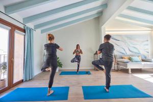 a group of people doing yoga in a living room at Son Sant Jordi in Pollença