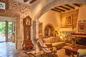 a living room with a couch and a grandfather clock at Son Sant Jordi in Pollença
