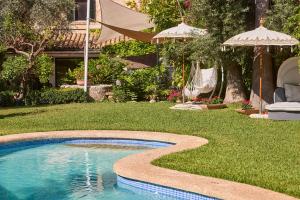 a swimming pool in a yard with an umbrella at Son Sant Jordi in Pollença