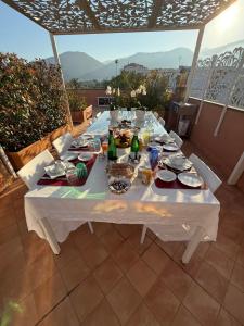 a white table with plates of food and drinks on it at The Rooftop Terrace b&b Two Double Rooms with private bathrooms and an equipped roof terrace in Sant'Agnello