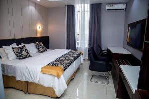 ein Hotelzimmer mit einem Bett und einem Flachbildfernseher in der Unterkunft Skyline View Hotels and Suites in Mama