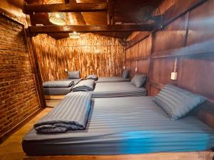 a row of beds in a room with wooden walls at Mota Homestay in Yên Minh