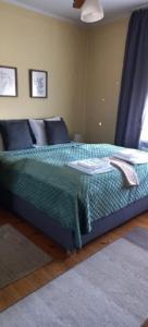 a bed with a green comforter in a bedroom at mieszkanie Tarnowskie Góry niedaleko Pałacu Rybna in Tarnowskie Góry
