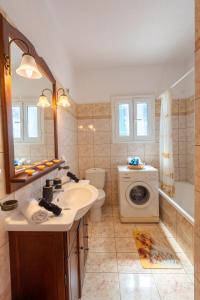 a bathroom with a sink and a washing machine at Rodinný dům THEMIS in Agios Georgios