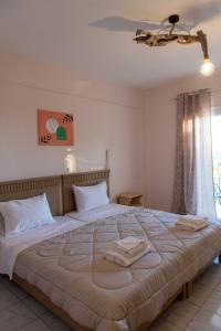a bedroom with a large bed with two towels on it at Sea and mountain hotel in Perdika
