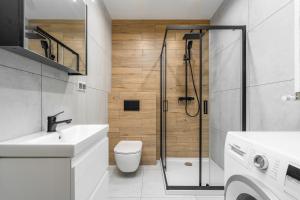 a bathroom with a shower and a toilet and a sink at Kawalerka z Klimatem in Szczecin