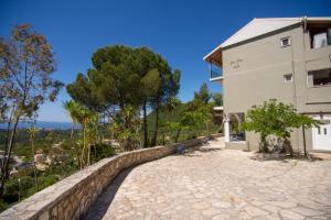 a house with a stone path next to a building at Sea and mountain hotel in Perdika