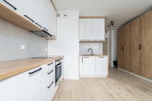 an open kitchen with white cabinets and a sink at Kawalerka z Klimatem in Szczecin