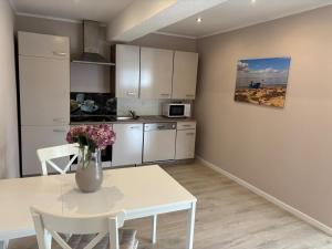 a kitchen with a table and a vase with flowers on it at Augustenhof Ferien in Nordborg