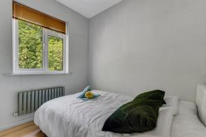 Hanwellにある2BR Garden Home Free Parking for 7 Guests Easy Access to London & Heathrowのベッドと窓のある白い寝室