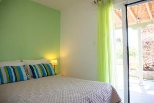 a bedroom with a bed and a large window at Stefanie Studios in Egina