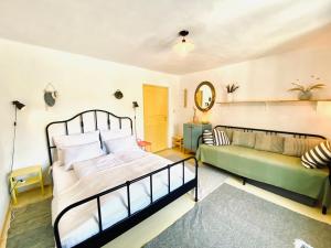 a bedroom with a bed and a couch at Bánhiday J70 Beach House in Balatonvilágos