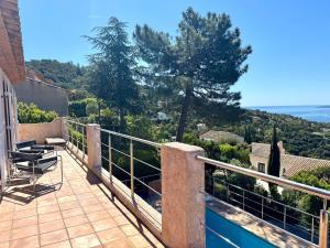 Un balcón de una casa con vista al mar. en Villa Luxe avec Vue sur Saint-Tropez, Roquebrune, en Roquebrune-sur-Argens