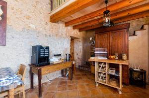 a kitchen with a wooden table with a microwave at YourHouse Agroturismo Can Porreti Sa Rota in Lloret de Vistalegre
