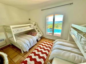 Dos literas en una habitación con ventana. en Villa Luxe avec Vue sur Saint-Tropez, Roquebrune, en Roquebrune-sur-Argens 32 fotos más