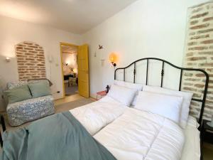 a bedroom with a large white bed and a chair at Bánhiday J70 Beach House in Balatonvilágos