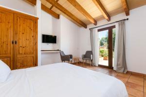 a bedroom with a white bed and a tv at YourHouse Agroturismo Can Porreti Sa Rota in Lloret de Vistalegre +21 photos
