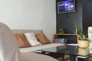 a living room with a couch and a table at Calma Chicha Rooms in Playa del Carmen