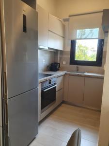 a kitchen with a white refrigerator and a window at Villa Modern Nikiti in Nikiti