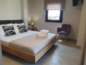 a bedroom with a bed with a chair and a window at Villa Modern Nikiti in Nikiti